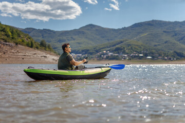 Fisherman in a canoe on a lake surrounded by mountains - Powered by Adobe