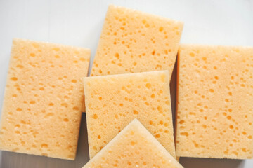 Yellow porous sponges on a white background. Top view. Copy, empty space for text
