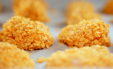 Chicken nuggets on parchment paper before baking.