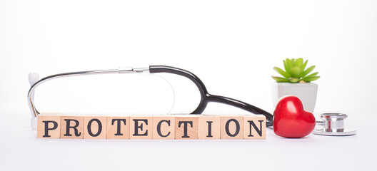 Panoramic close up banner horizontal view photo of stethoscope red heart and wooden blocks showing word protection isolated white background