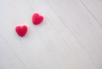 Two sweet red candy heart shape on white wooden background. Valentine's day, romantic concept. Minimalism. Top view. Selective focus. Copy space