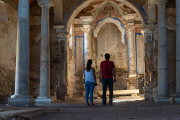 Caucasian couple in Juromenha abdandoned castle church interior in ruins in Alentejo, Portugal