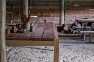 Interior of a wooden hut. Wooden logs and table. Slavic medieval house. - obrazy, fototapety, plakaty
