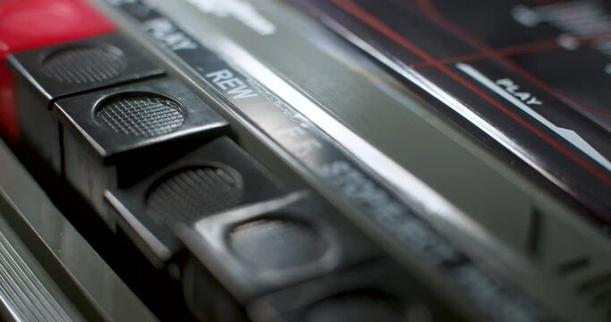 Rewind and Fast Forward Buttons. A macro close up of the rewind and fast-forward buttons being pressed on an old audio cassette player.