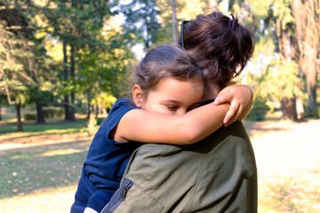Affectionate mother and daughter embracing at the park.