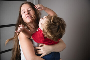 A woman with her son in her arms. Happy family. Real emotions.