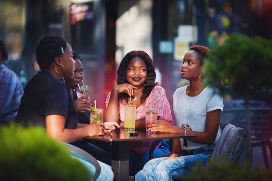 beautiful african american girls talking, sitting in summer cafe