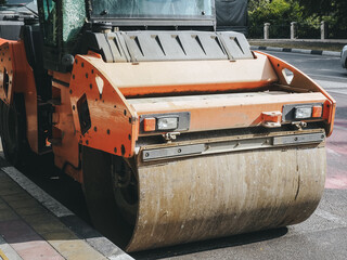The road roller stands near the curb on the road. Road service. Closeup photo