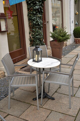 Table with chairs in front of cafe with christmas decoration on street
