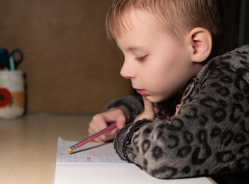 First Grader Boy Doing Homework In The Evening