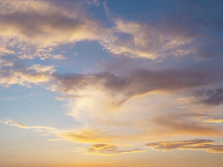 Naklejka na ściany i meble Clouds illuminated by sunset sunlight in the blue sky. Background texture. Fullscreen photo