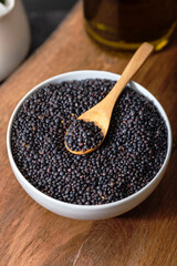Beluga. Black lentil in scoop on wooden background.