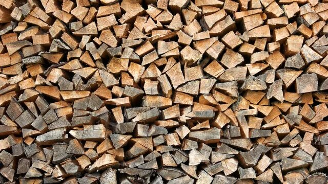 Stacked pile of chopped wood. Stacked dry firewood logs close up. Wood for winter heating in the village stove.