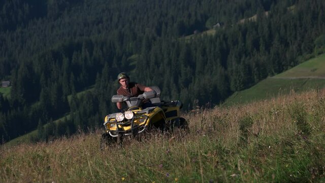 Man driving quad bike in summer mountain. Men in helmets driving quad bikes. Beautiful nature background.