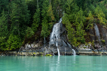 Fototapeta na wymiar Small waterfall falling into a glacial water