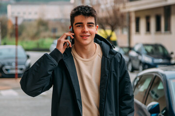 young teenager talking on the phone walking down the city street