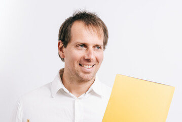 Young man facing forward while holding a yellow folder