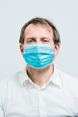 Closeup of young man looking in to the camera with mask holding it on hands.