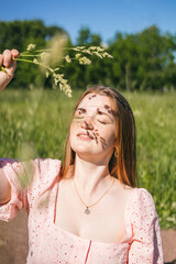 Fototapeta premium Girl on a sunny day in the park with a shadow from moles on her face. Stylish visual for social networks