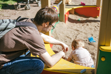 One year old toddler playing in the sandbox