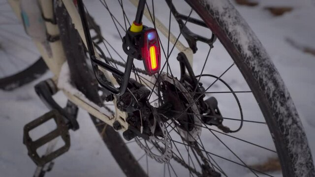 flashing rear light mounted on a touring bike against snowy trail