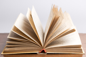 open old book on desk over grey background. education concept