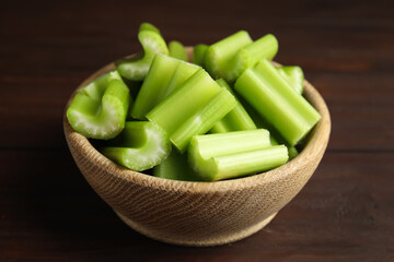 Cut celery in bowl on wooden table