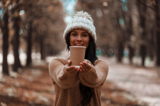 Fall concept - autumn woman drinking coffee on park 