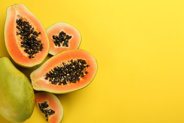 Fresh ripe papaya fruits on yellow background, flat lay. Space for text