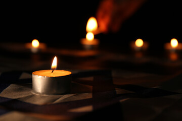 Burning candle on flag of Israel. Holocaust memory day