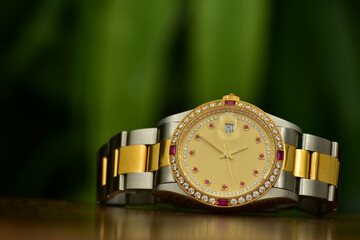 A gold watch with a gold dial and precious stones.