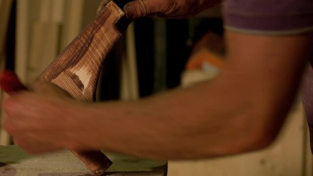 Carpenters hand covering wood with a lacquer. Handyman varnishing wood at carpentry workshop. Polish wood with protective varnish.