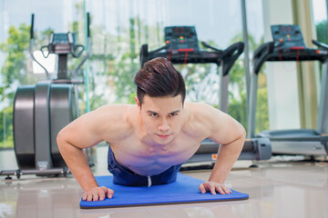 Fototapeta na wymiar Asian man Push up in gym for bodybuilding