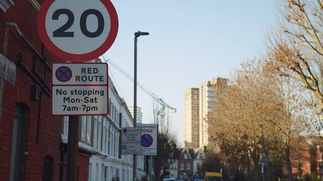 MAXIMUM SPEED LIMIT OF 20 MILES PER HOUR traffic road sign in 4K. No stopping during times shown except for as long as necessary to set down or pick up passengers. Red route.