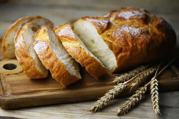 Selective focus. Fresh wheat bread on the board. Bread in slices.