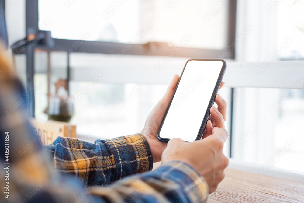 Wall mural cell phone blank white screen mockup.woman hand holding texting using mobile on desk at office.backg