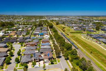 Aerial view of an outer suburb in Melbourne with train passing by - 405013215