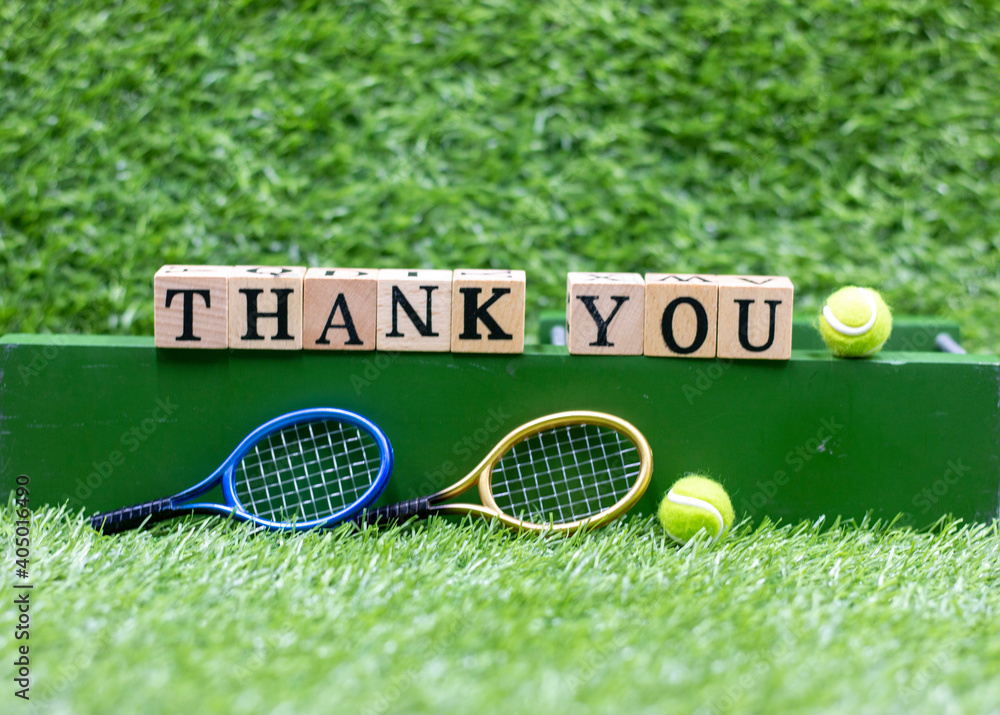 Wall mural tennis ball and racket with thank you word on green grass background