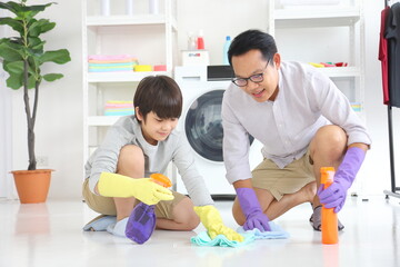 Asian father and son help each other to clean the floor for daily routine chores and housekeeping...