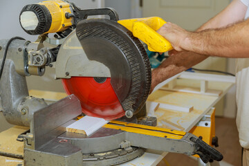 Man cut the wooden molding with circular saw