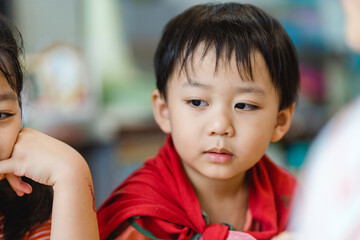 Happy family lockdown activity at home.Asian Mother and children are learning bible sunday school study online for bible story.Mom woman teaches her child.Sibling kids learning at home during covid19.