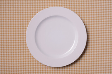 茶色いチェック柄の上の白い皿