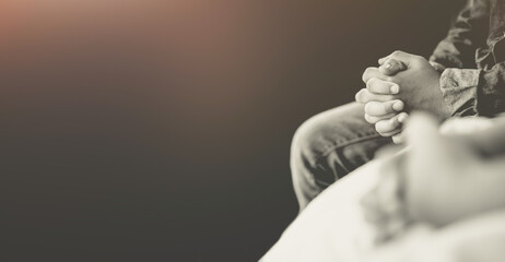 man praying worship at home on black background.Teenager hand praying,Hands folded in prayer.Good friday, Easter, forgiveness.Concept for faith, people, fasting and religion.stay home, lockdown.