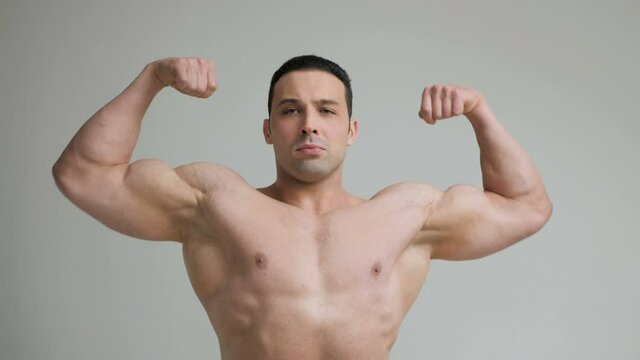 Bodybuilder shows strong biceps on a white background