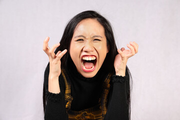 Young attractive southeast Asian woman posing facial expression question crazy hand raised angry upset