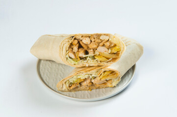 Side view of Grilled Meat shawarma roll served on gray plate, isolated on background. Cheesy Gyros...