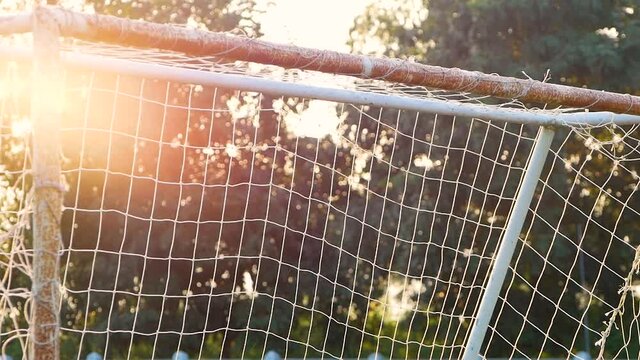 Olded football goal sports equipment with sunshine in the field.
