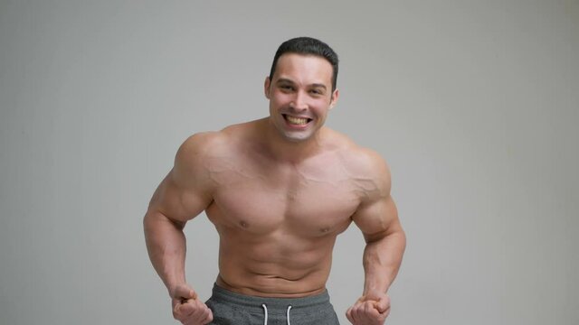 Bodybuilder shows strong biceps on a white background