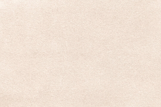 Light beige matte background of suede fabric, closeup. Velvet texture of  textile Stock Photo