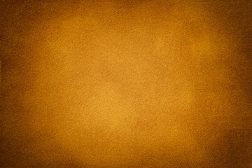 Orange matte background of suede fabric with vignette. Texture of velvet textile